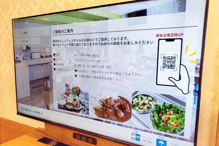 ホテルマークワン株式会社 様 テレビに朝食会場の様子を確認できるページが表示されている写真